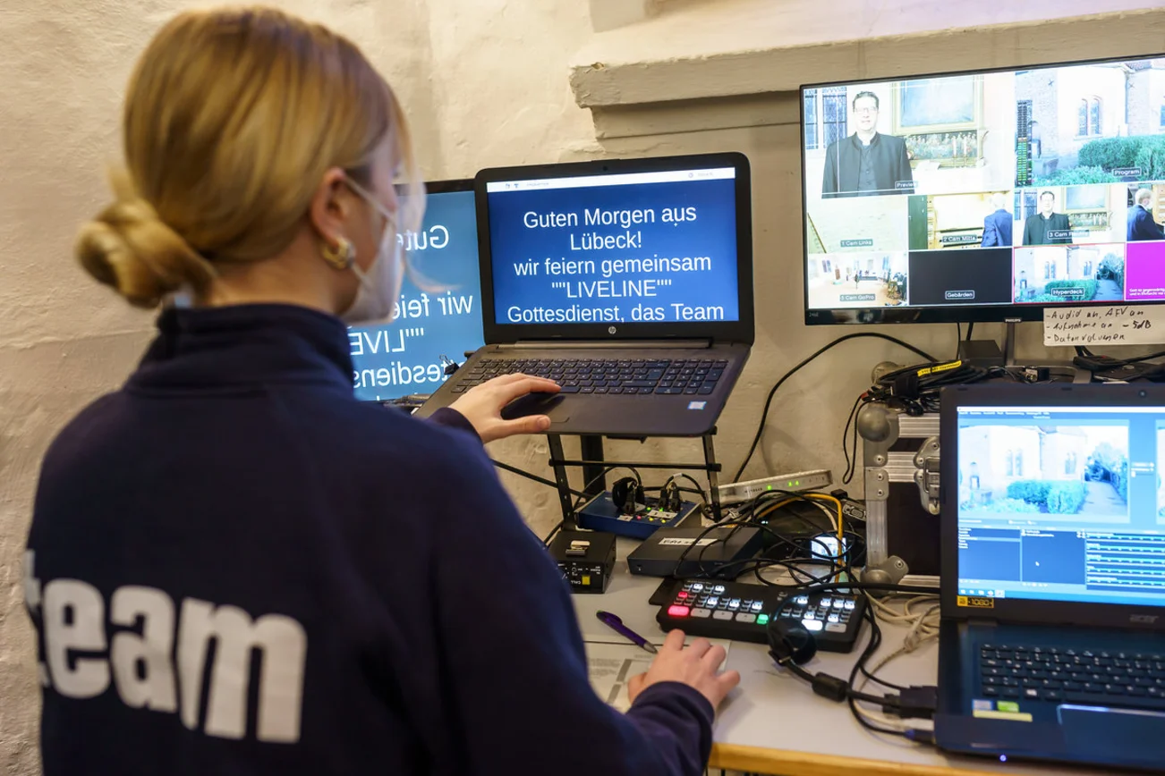 Eine Jugendliche sitzt im Schnittraum und schaut auf Bildschirme. 